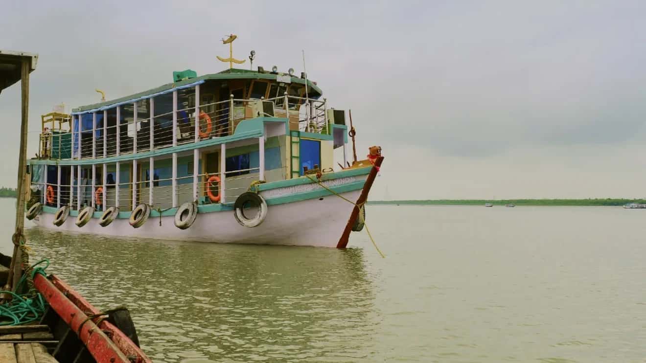Whispering Winds houseboat on the Sundarban river in daylight